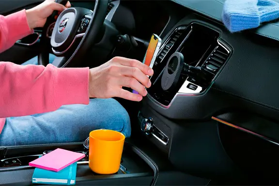 Een iPhone laadt inductief op in de auto via een houder op de ventilatiesleuven.