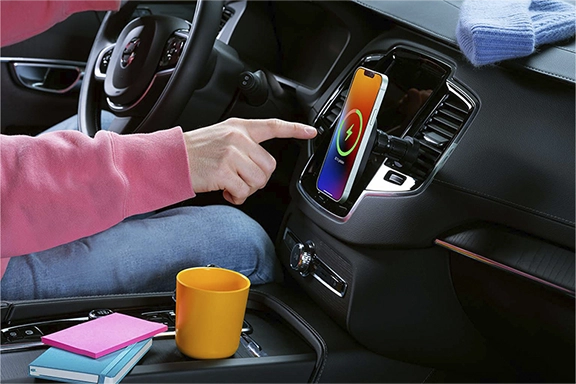 Een mobiele telefoon laadt op een MagSafe autohouder, bevestigd op de ventilatiesleuven.