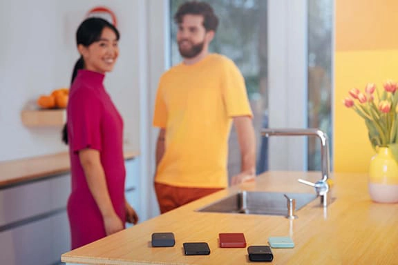 Meerdere powerbanks liggen op een balie, vrolijke mensen op de achtergrond