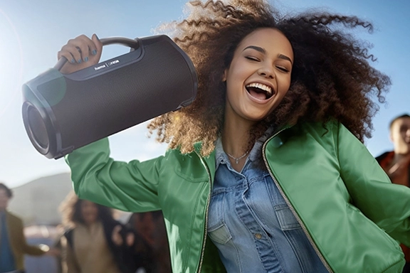 Vrouw viert uitbundig feest met Hama Bluetooth®-luidspreker "Mate Pro"